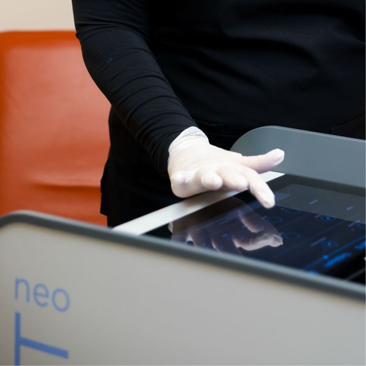 A specialist dials in a patients' protocol on a touchscreen during their Emsculpt NEO near Barrington Hills.